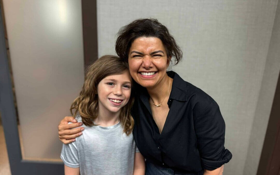 Happy child and woman, possibly a kids orthodontist, smiling together.